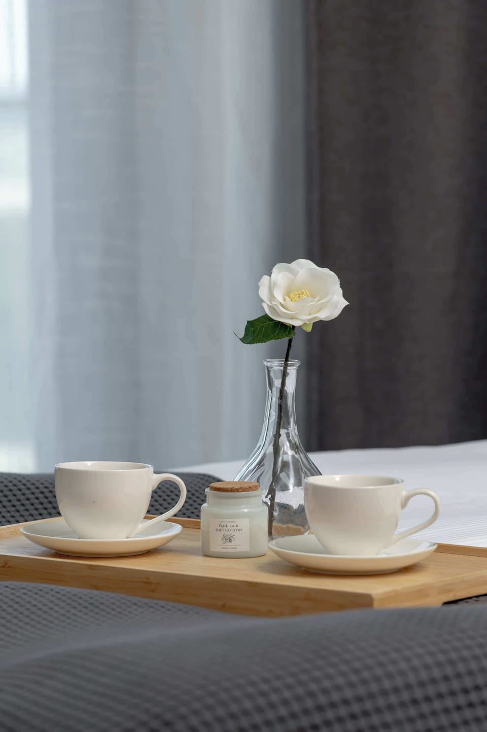 Cosy bedroom detail with small table and decorative flowers.