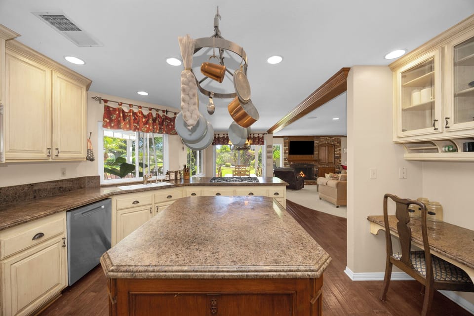 Fully equipped gourmet kitchen with a large center island, breakfast bar, and open-concept design overlooking the family room.