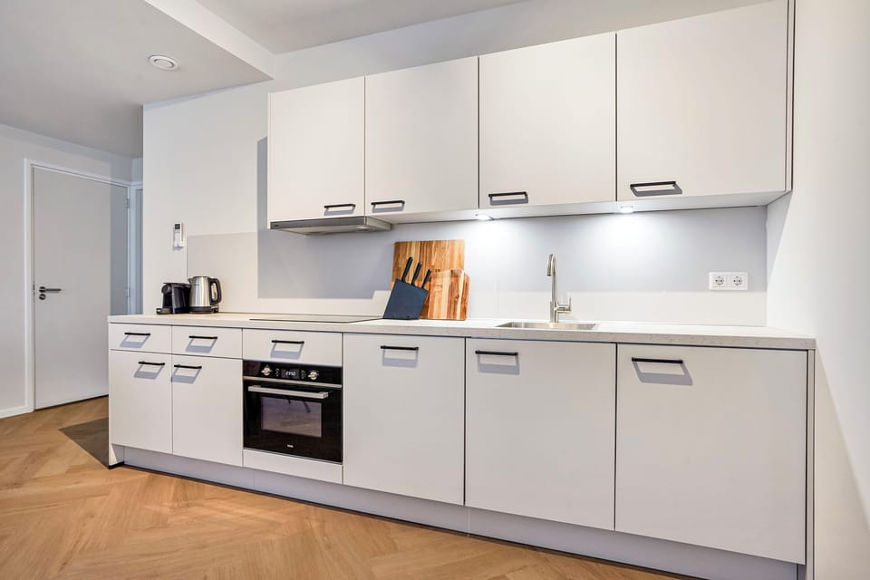 Fully equipped private kitchen with induction cooktop, microwave-oven, dishwasher, refrigerator, coffee machine, and everything needed for home cooking.