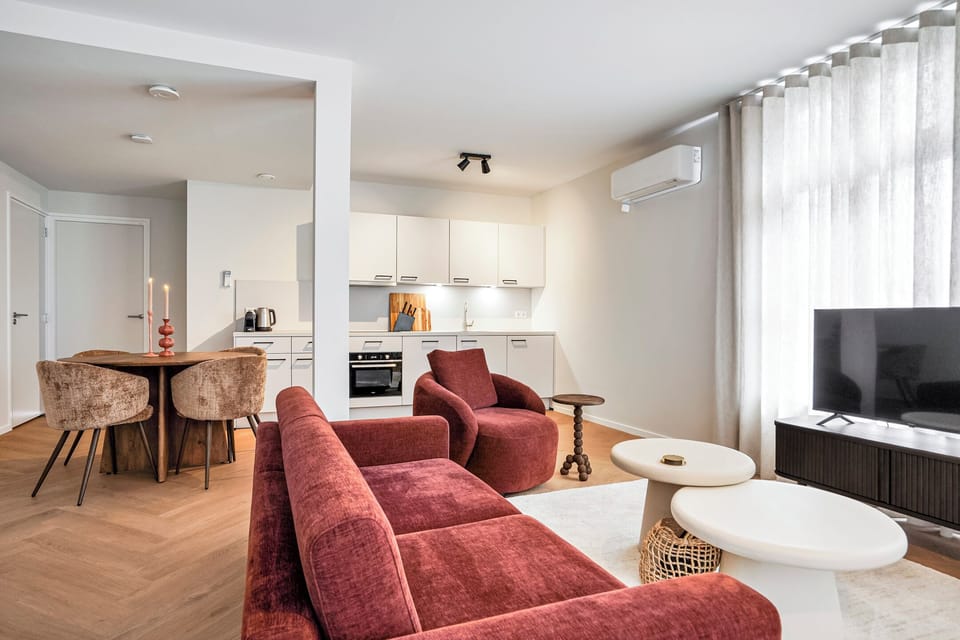 Enjoy the spacious open-concept living area with Smart TV, air conditioning, and a fully equipped kitchen designed for comfort and convenience.