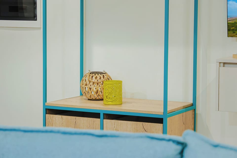 Your cozy bedroom features cheerful turquoise accents and thoughtful storage, with handcrafted décor adding warmth and character to your relaxing retreat.