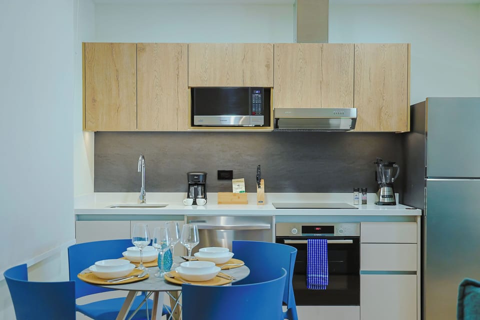 Your modern kitchen is fully equipped with everything you need, from a sleek microwave and coffee maker to a stocked dining table ready for meals with loved ones.