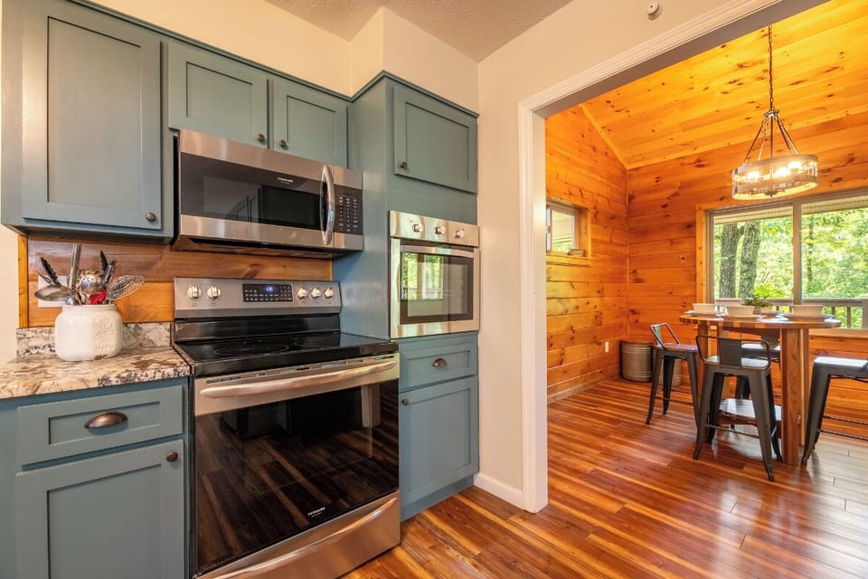 Your well-appointed kitchen flows effortlessly into a warm, sunlit dining nook—perfect for morning coffee or home-cooked meals with loved ones. Rich wood tones and natural light create a cozy mountain retreat feel.