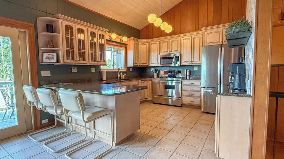 Your spacious kitchen features stainless steel appliances, granite countertops, and a welcoming breakfast bar perfect for morning coffee or casual meals together.