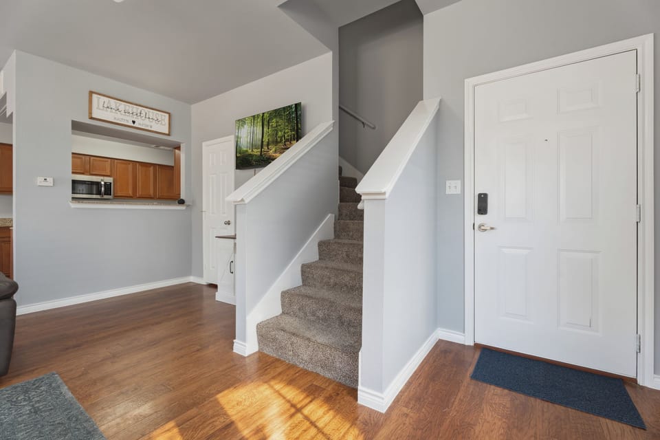 Bright entry with smart lock, hardwood floors, and open kitchen pass-through