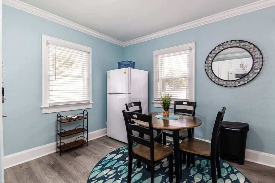 This inviting dining area comfortably seats four and is bathed in natural light, creating a warm and welcoming atmosphere. The cheerful decor, with its vibrant colors and charming accents, makes it the perfect spot for enjoying meals.