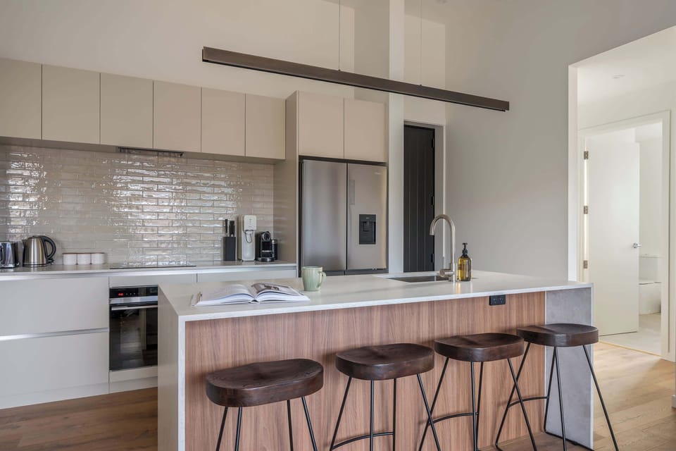 A sleek, fully equipped kitchen, with a walnut island and stools made for lingering over coffee.
