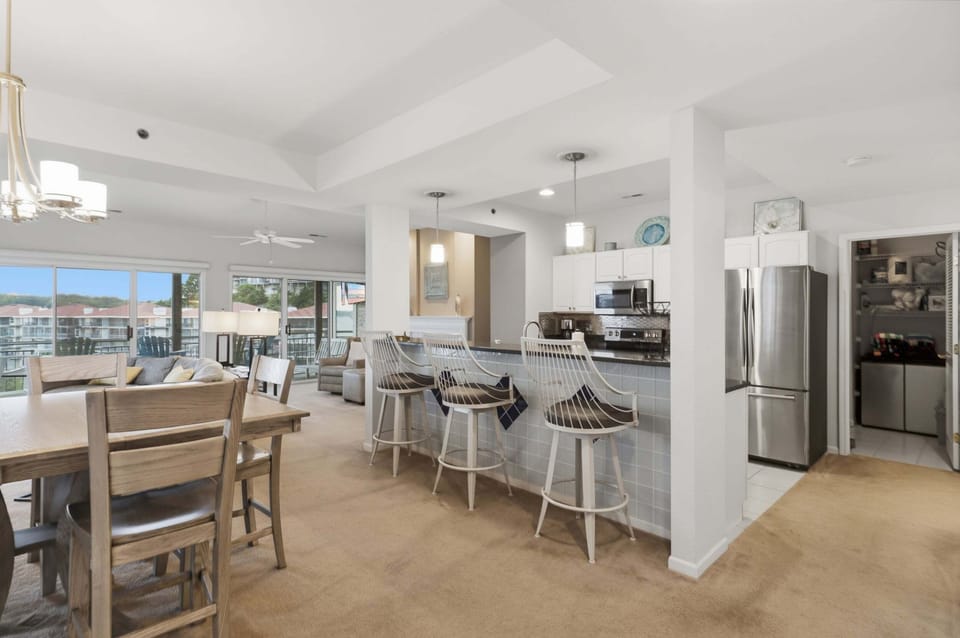 Fully equipped kitchen with a breakfast bar, open dining area, and seamless flow into the lakeview living space.