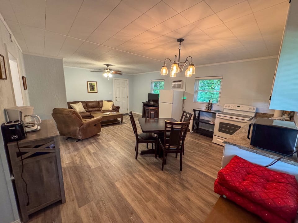 Step into a spacious, open-concept living area that seamlessly connects the inviting living room, dining space, and fully equipped kitchen, perfect for gathering and entertaining.