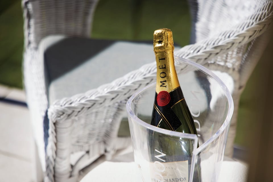 Elegant patio moment with chilled champagne and wicker seating