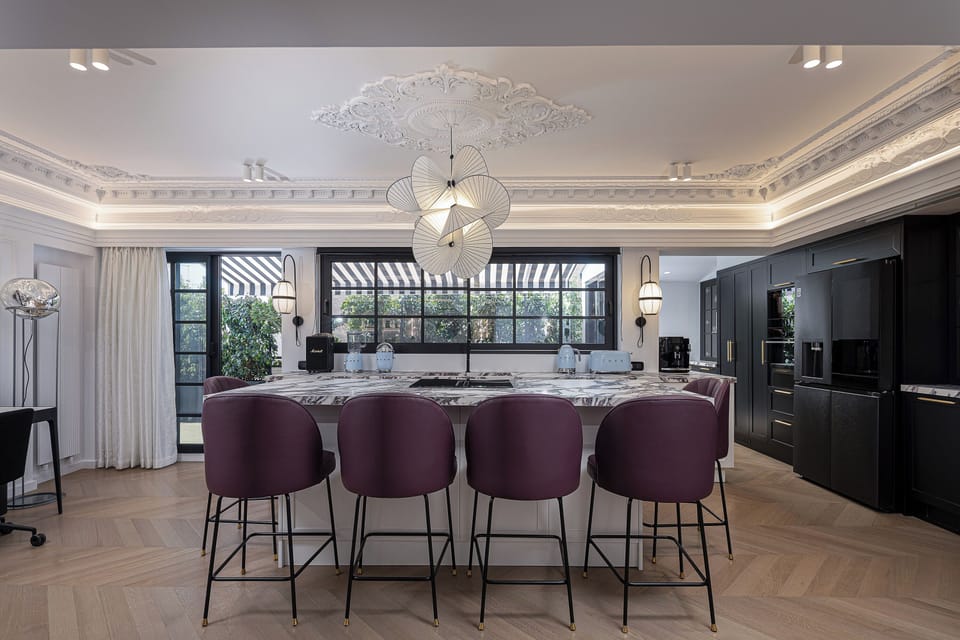 Stylish open-plan kitchen with high-end appliances, wine cooler, and coffee machine, seamlessly connected to the living space for effortless dining and entertaining in central Athens.