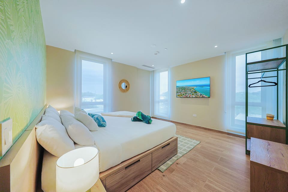 Wake up to stunning island views framed by floor-to- ceiling windows. Your bright, airy bedroom features a plush king bed and tropical accents that bring calm, coastal vibes inside.