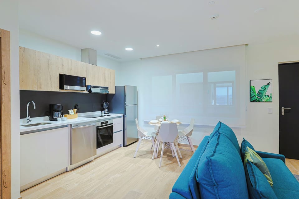 Relax in your bright, modern open-plan space featuring a fully equipped kitchen, dining area, and comfortable seating—everything you need to feel at home during your stay.