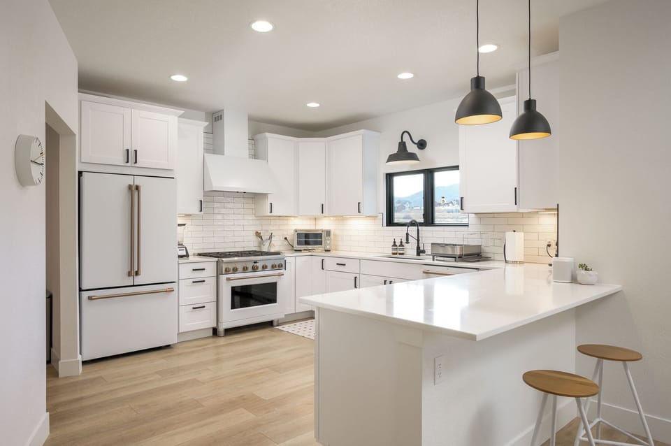 Enjoy preparing meals in this bright, modern kitchen with sleek white cabinetry, stainless appliances, and a spacious island—perfect for cooking and gathering with loved ones.