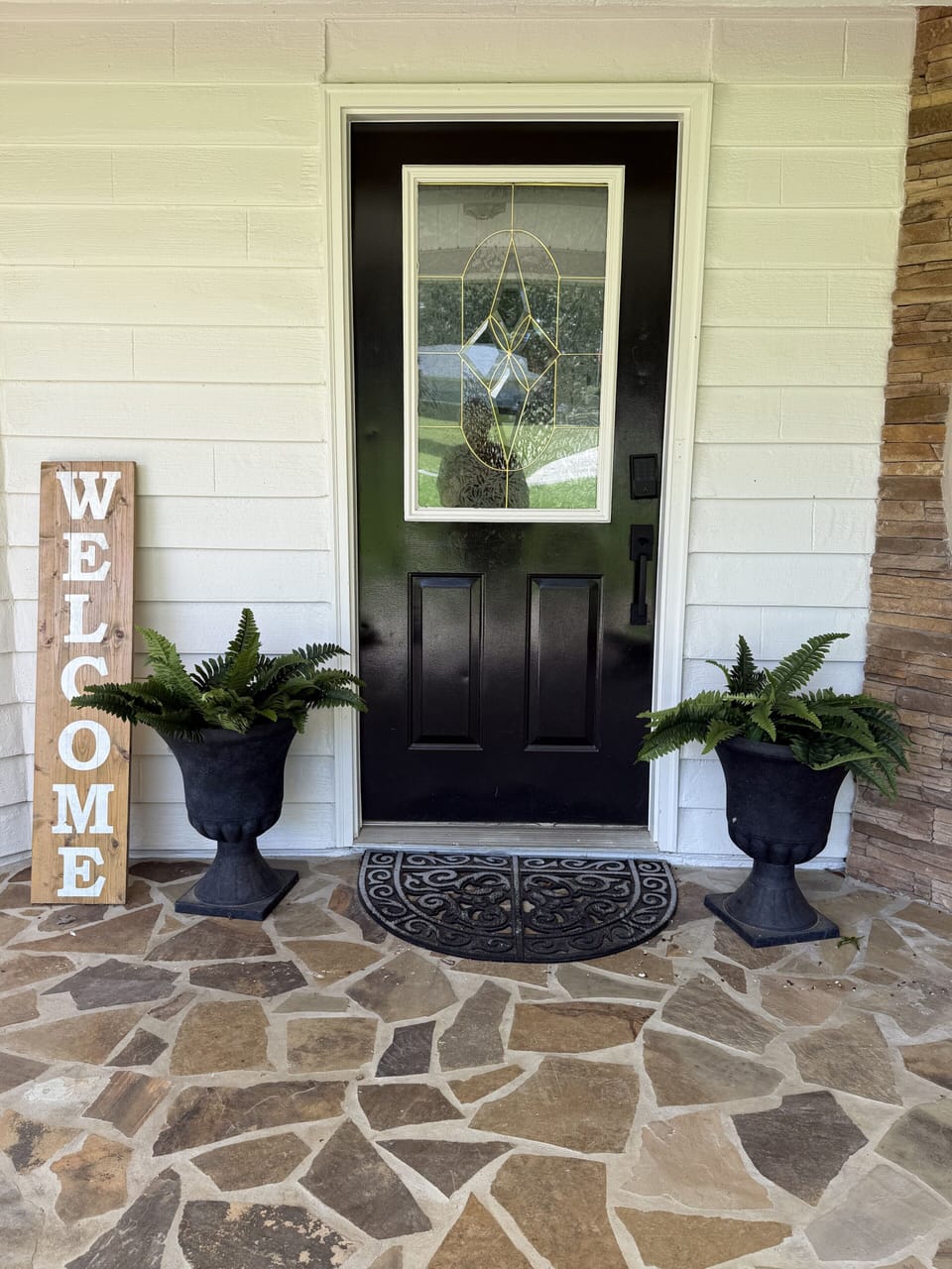 Charming stone porch entry with elegant glass door and welcoming decor