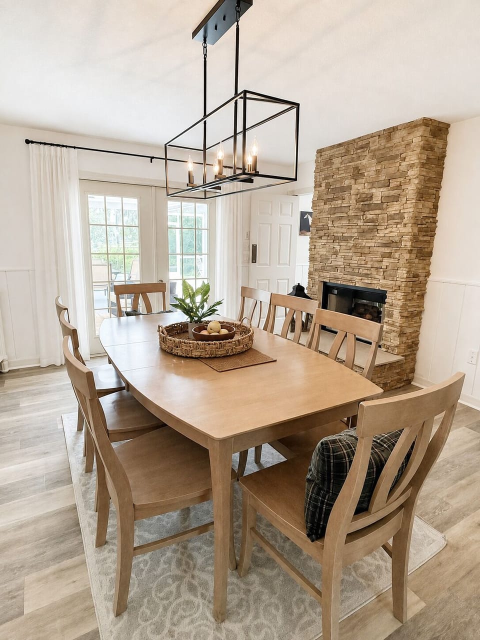 Bright dining room for 8 with modern lighting and a stunning stone fireplace