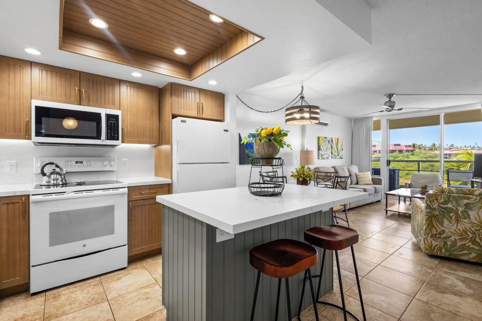 Step into your fully equipped kitchen where a spacious island with bar seating invites casual meals and morning coffee. Through the open layout, you'll enjoy golf course views framed by bright windows and a welcoming living space.