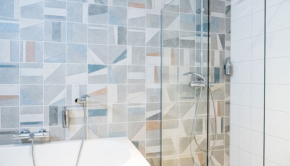 Unwind with a warm shower in the modern tiled bath.