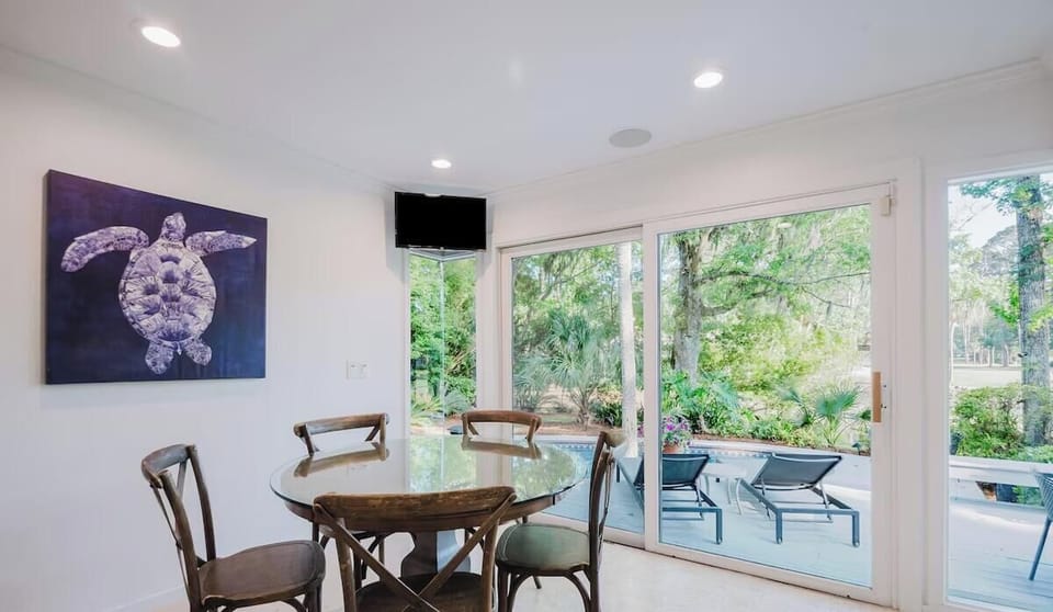 Enjoy your morning coffee at this charming dining table with views of lush tropical greenery and the pool deck just beyond your door.