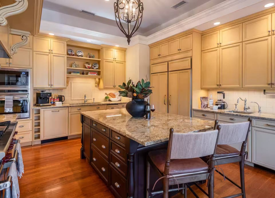 This expansive gourmet kitchen features a massive granite island with bar seatin