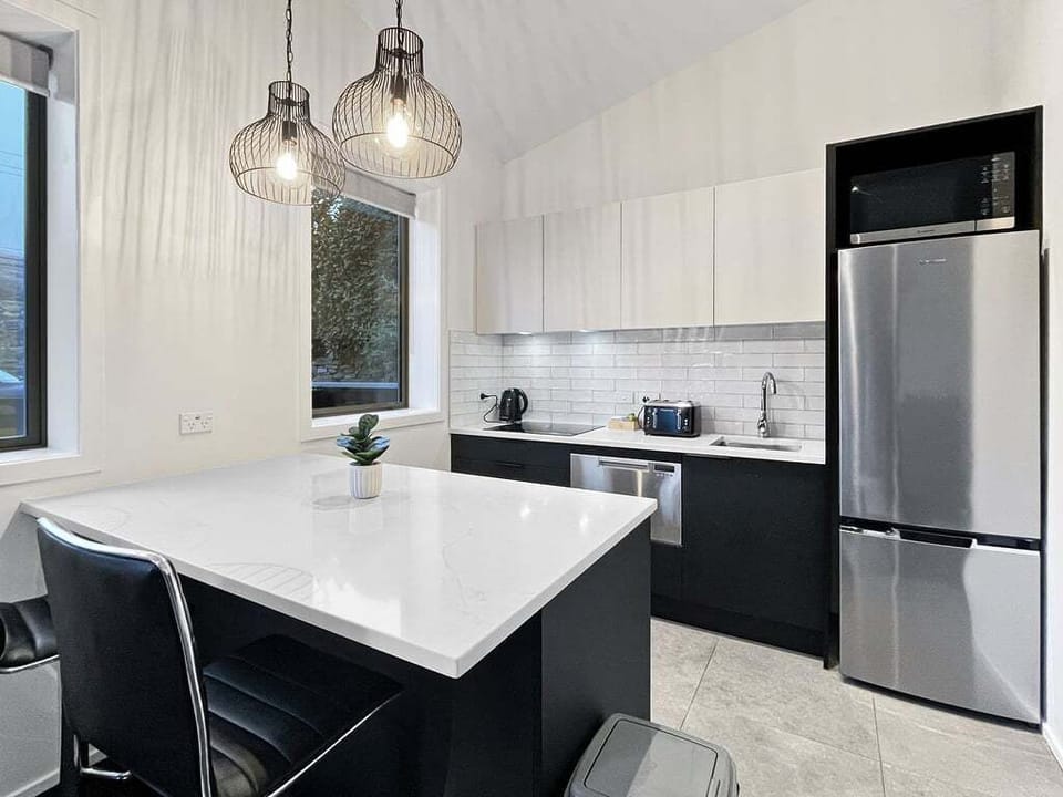 Fully equipped kitchen with modern appliances and breakfast bar seating.