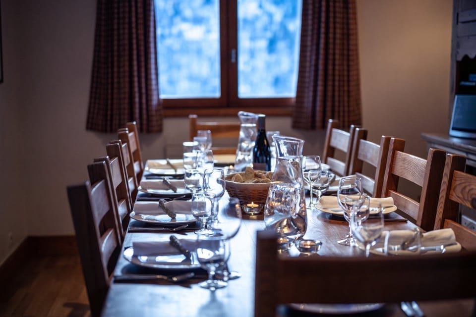 Elegant glassware and linen napkins dress this table for an intimate dinner against the snowy backdrop.