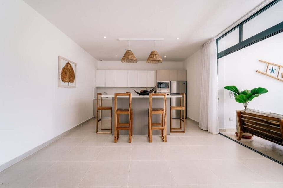 Fully equipped kitchen with a breakfast bar and four stools, perfect for preparing meals and enjoying a quick bite.