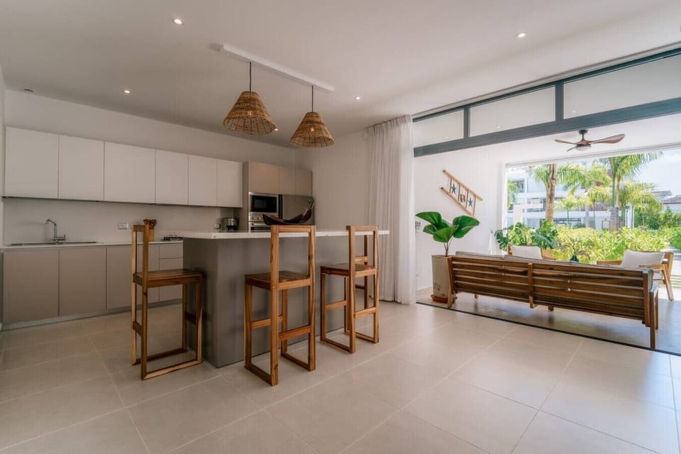 Modern kitchen with a breakfast bar, high stools, and easy access to the outdoor seating area.