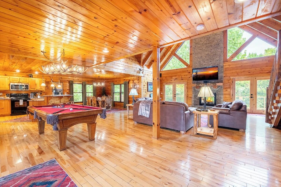 Your spacious great room blends rustic charm with modern comfort, featuring soaring wood ceilings, a pool table for friendly competition, and a cozy fireplace perfect for unwinding after a day of adventure.