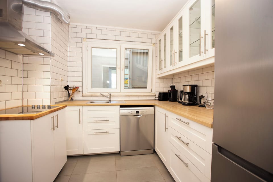 Bright modern kitchen with wood counters and stainless appliances