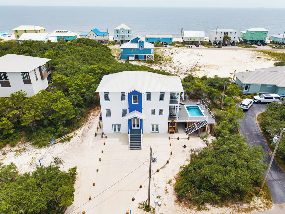Large driveway with parking for up to 7 vehicles. Outdoor amenities including sand volleyball court, elevated private pool, and charcoal grill. 