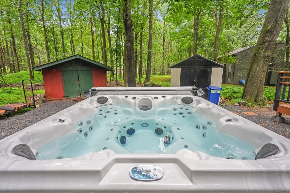 6-person hot tub with LED-lit jets, bubbling in the private wooded backyard