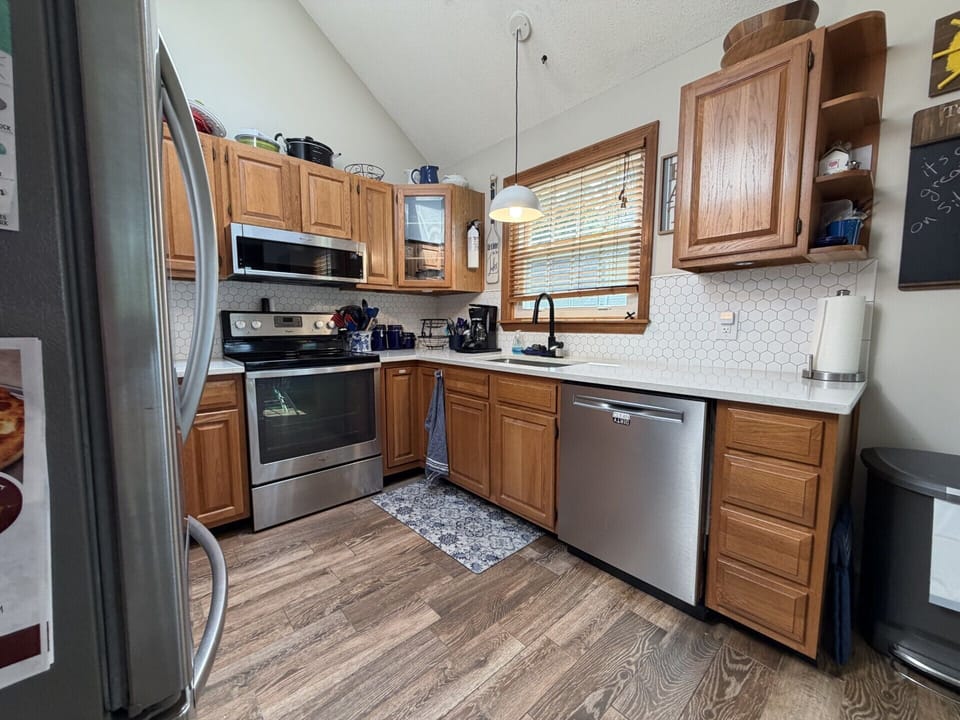 Step into your fully equipped kitchen with stainless steel appliances, warm wood cabinetry, and bright natural light—everything you need to whip up a delicious meal during your stay.