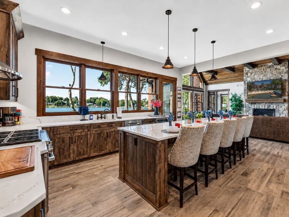 Gourmet group kitchen with an oversized island, five stools, premium appliances and lake views.