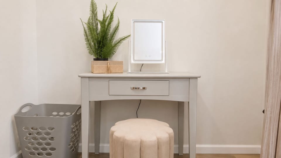 Bright vanity nook with mirror, soft seating, and thoughtful touches