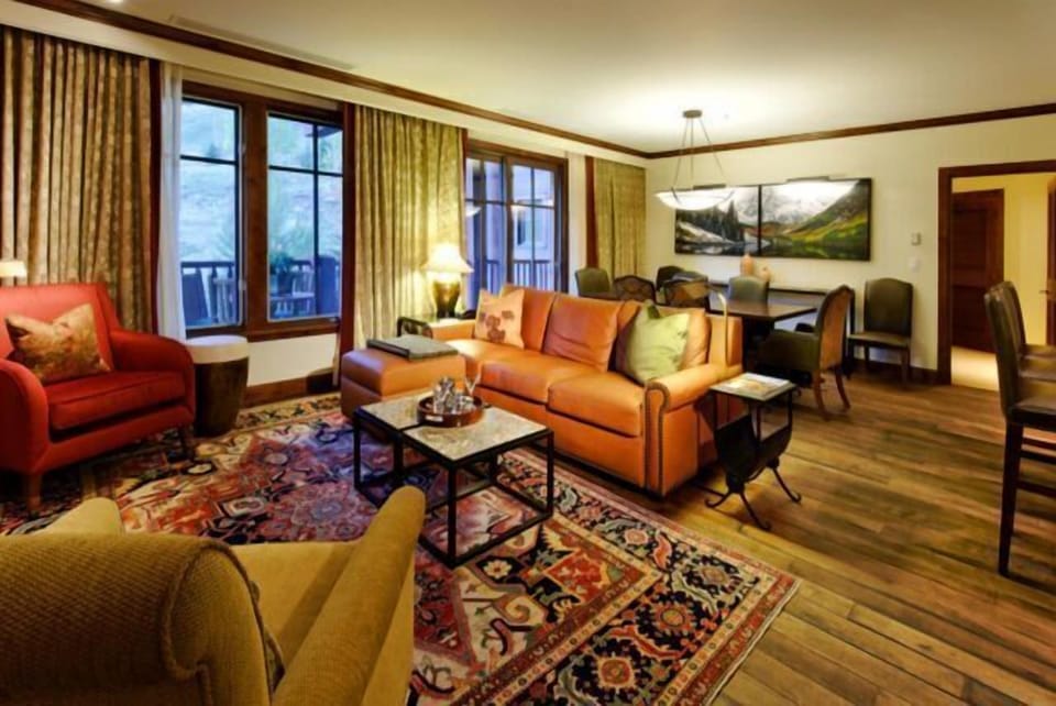 Cozy mountain-style living room with large windows and dining space
