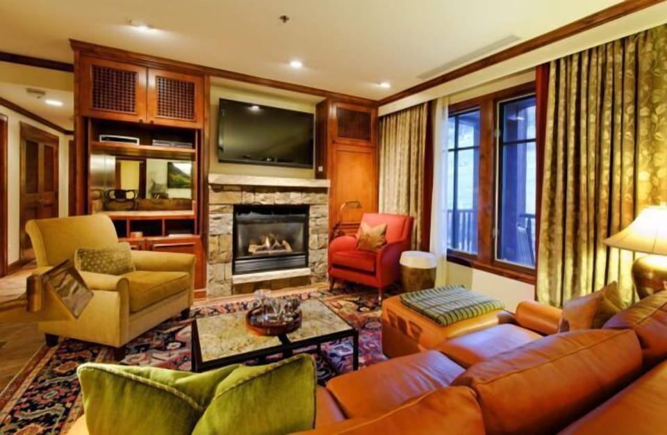 Cozy lodge-style living room with fireplace, TV, and plush seating