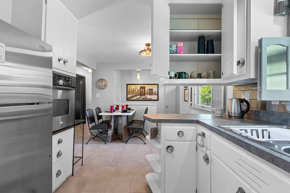 Bright full kitchen with dining nook and stainless steel appliances