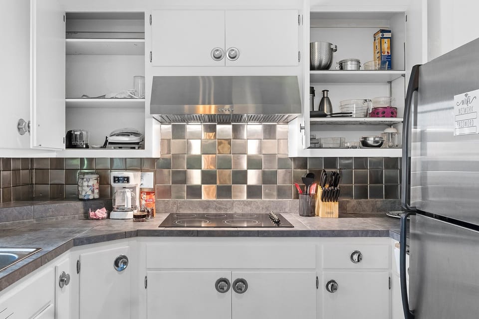 Bright kitchen with stainless appliances and a sleek modern backsplash
