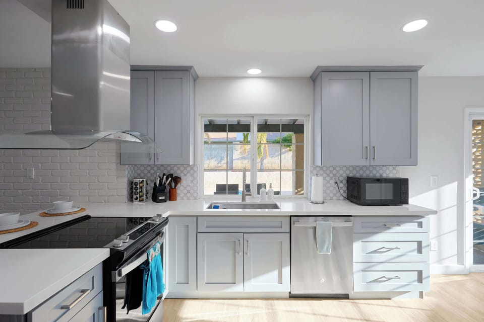 Kitchen comfort meets full function with a spacious island seating three, stainless steel appliances, and a sleek range hood, plus a coffee bar.