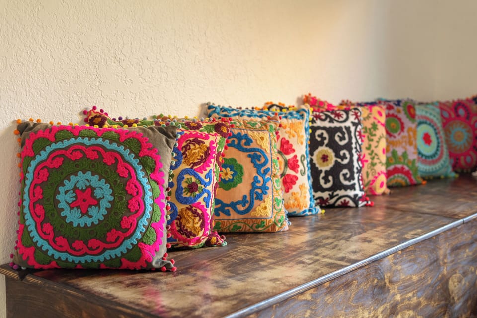 Vibrant, embroidered throw pillows add a pop of color and comfort throughout the home.