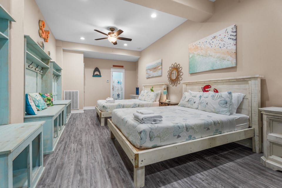 Provides generous sleeping space with two queen beds and built-in bunks. The spacious layout makes this coastal bunkroom a comfortable choice for families and groups.
