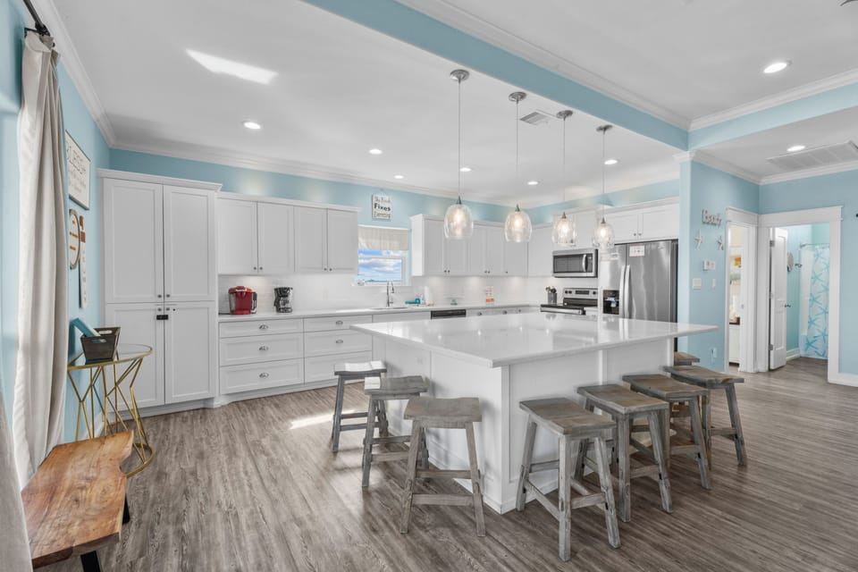 The bright open-concept kitchen features a spacious island, bar seating, and an adjoining dining area.