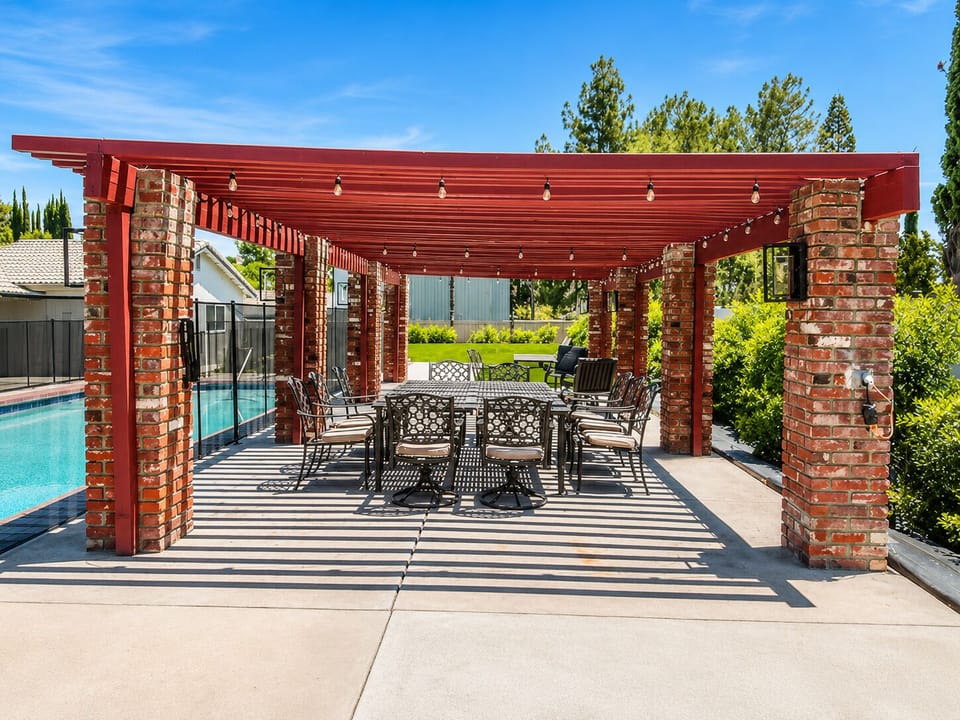 Shaded poolside pergola with outdoor dining for relaxed group gatherings