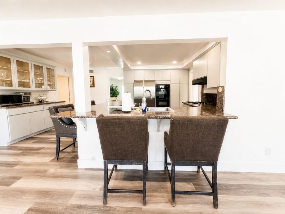 Bright open kitchen with breakfast bar, stylish seating, and modern finishes