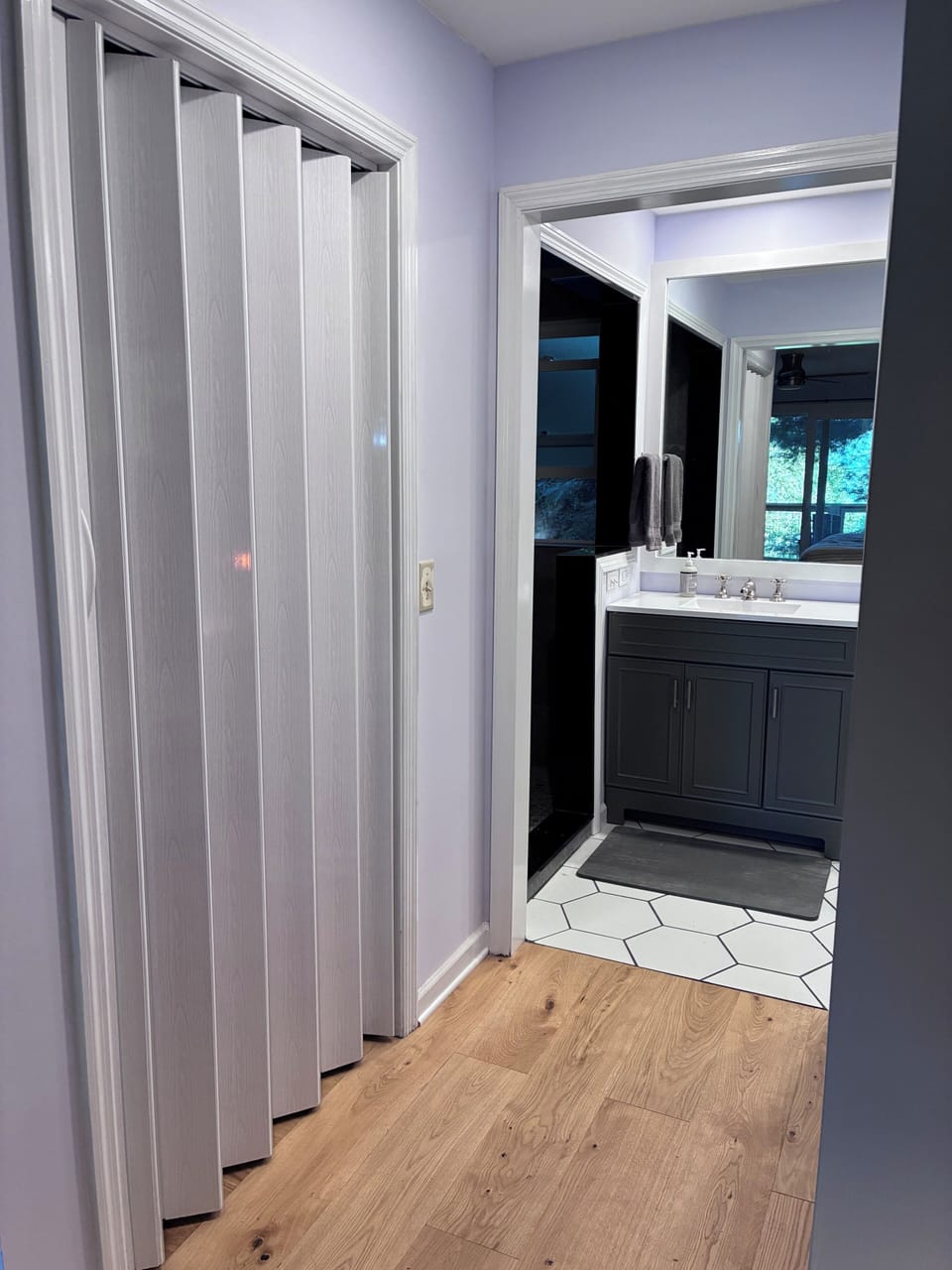 Primary bedroom with walk-in closet, double vanities and stone bath mats.