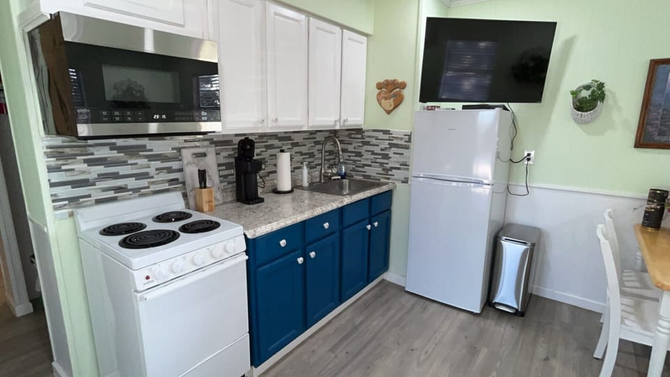 Bright updated kitchen with coffee station, full appliances, and TV