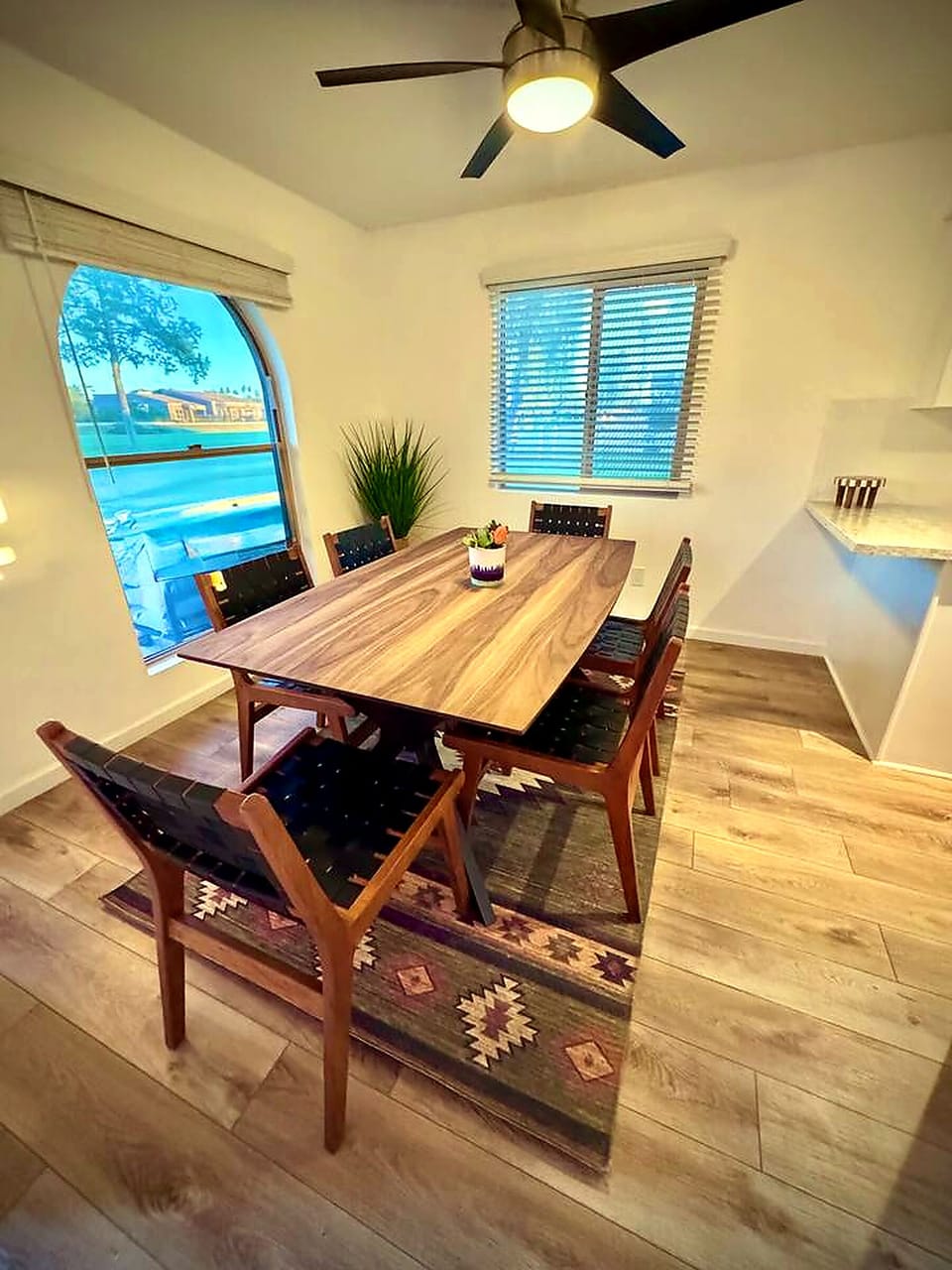 Bright dining nook with seating for 6, natural light, and stylish wood finishes
