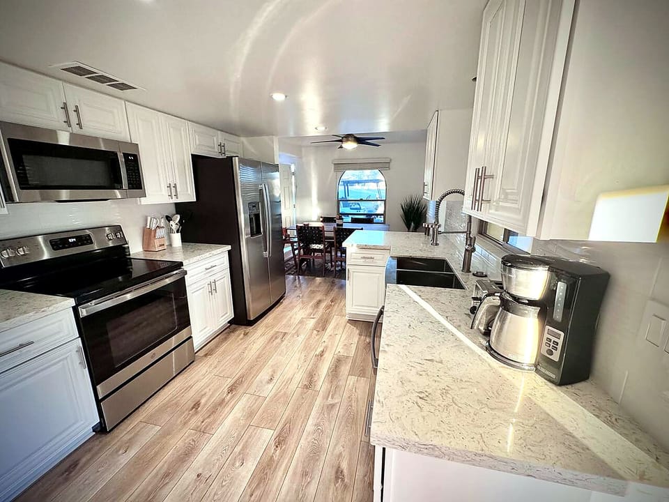 Bright modern kitchen with stainless appliances and dining area