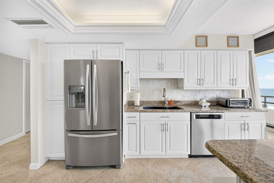 Whip up your favorite meals in this bright, fully-equipped kitchen with stainless appliances, granite counters, and stunning ocean views just steps away.